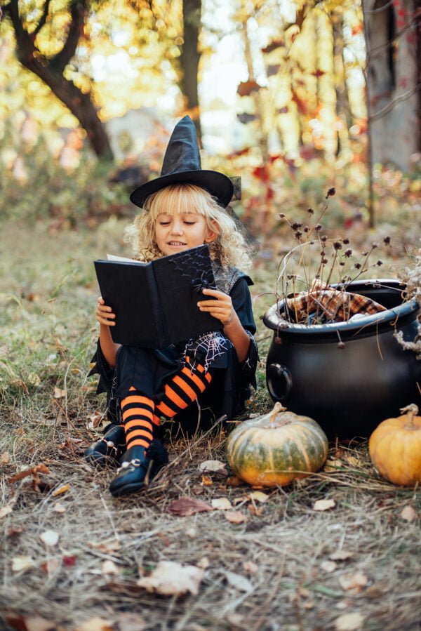 Beautiful girl witch. little girl in which costume celebrate Halloween outdoor and have fun